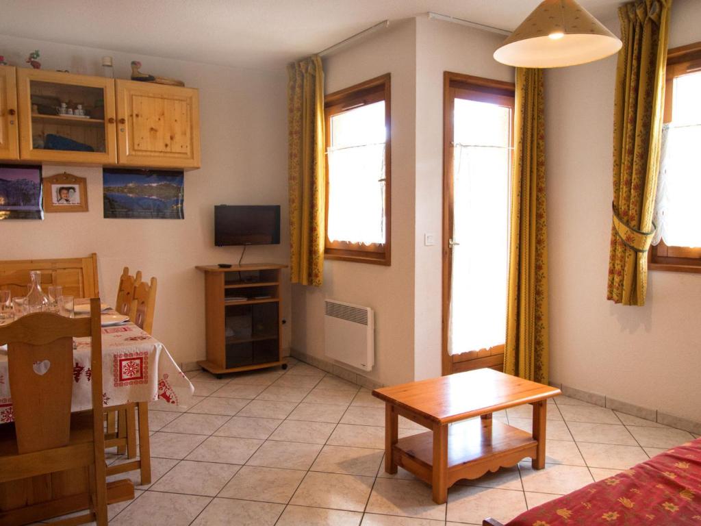 un salon avec une table et une télévision dans l'établissement Appartement cosy à Aussois, 6 personnes, parking inclus - FR-1-508B-11, à Aussois
