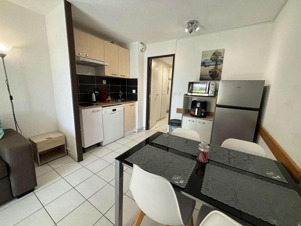 une cuisine avec une table et des chaises dans une pièce dans l'établissement Appartement 2 pièces avec terrasse et vue piscine à Cannes la Bocca - FR-1-609-112, à Cannes