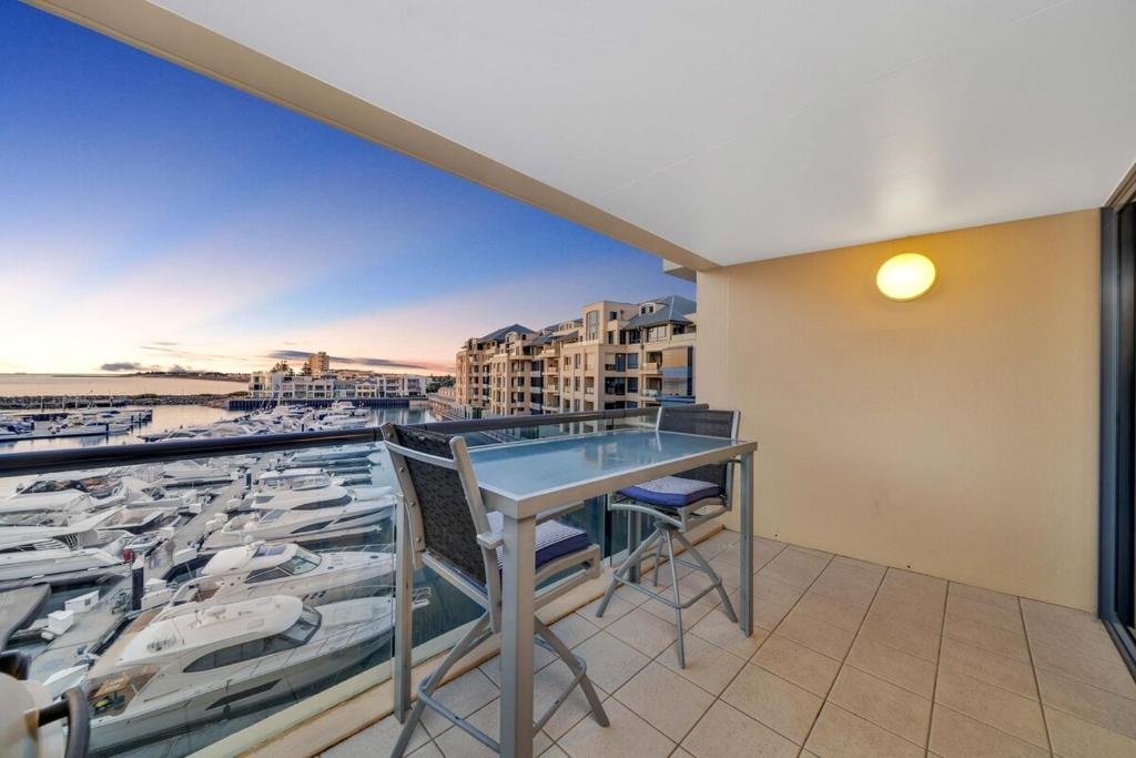 a balcony with a table and a view of a harbor at Sub-Penthouse with Marina View by Host Solutions in Glenelg