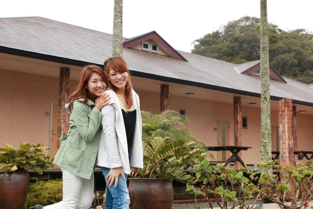 Zwei Frauen stehen vor einem Haus in der Unterkunft Sunny Spot in Minamitan
