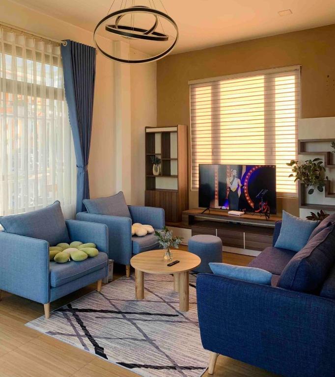 a living room with blue couches and a tv at Dalat Healing House - Villa Săn Mây Siêu Đỉnh in Da Thanh