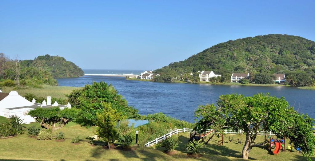 uma vista para um rio com casas e árvores em The Estuary Hotel & Spa em Port Edward