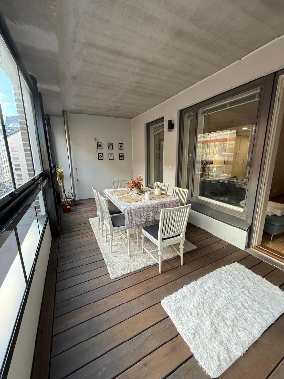 a dining room with a table and chairs on a balcony at Modern Flat in City in Helsinki
