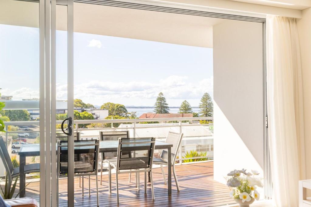 a dining room with a view of the ocean at Cote D'Azur 42, 61 Donald St - complex pool, lift, linen, bed making and stunning water views in Nelson Bay