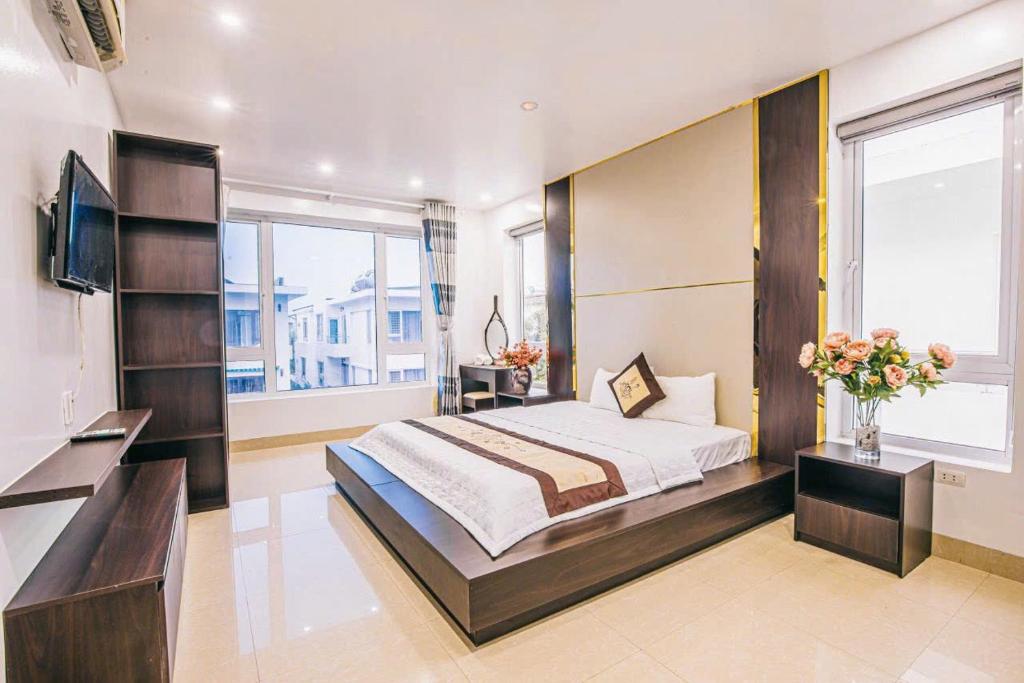 een slaapkamer met een groot bed en een televisie bij Villa NT119 FLC Sầm Sơn in Sầm Sơn
