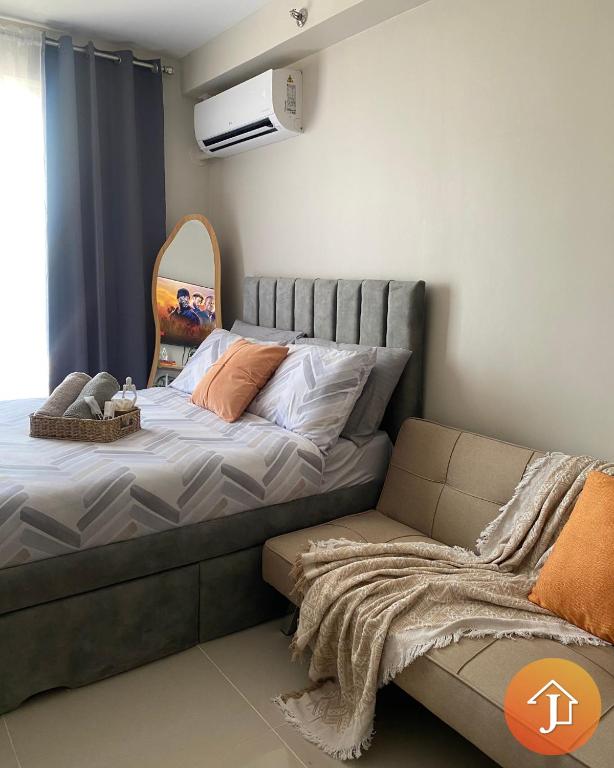 a bedroom with a bed with a couch and a mirror at Studio With Balcony Near Beaches in Mactan in Lapu Lapu City