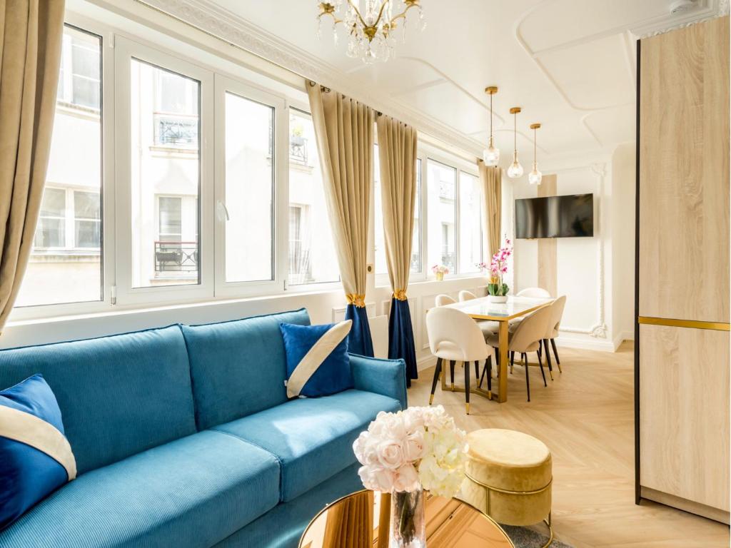 un salon avec un canapé bleu et une table dans l'établissement Merveil - Luxury Suite - Marais - Poissonniere, à Paris
