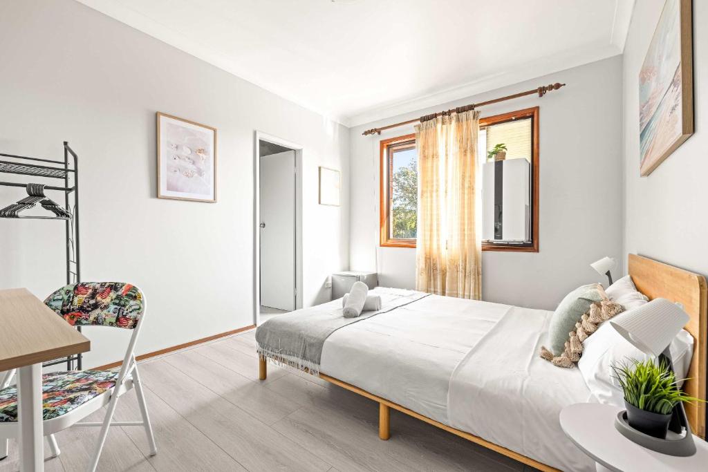 シドニーにあるLive in Comfort - Ensuite Double Room in the Heart of Belmoreのベッドと机と椅子のある寝室