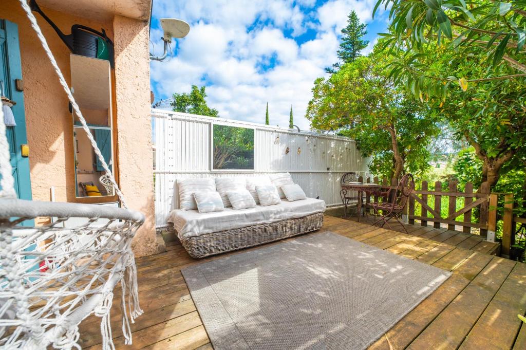 d'une terrasse en bois avec un canapé. dans l'établissement Nid Bohème en Provence Calme & Terrasse Zen, à Lorgues