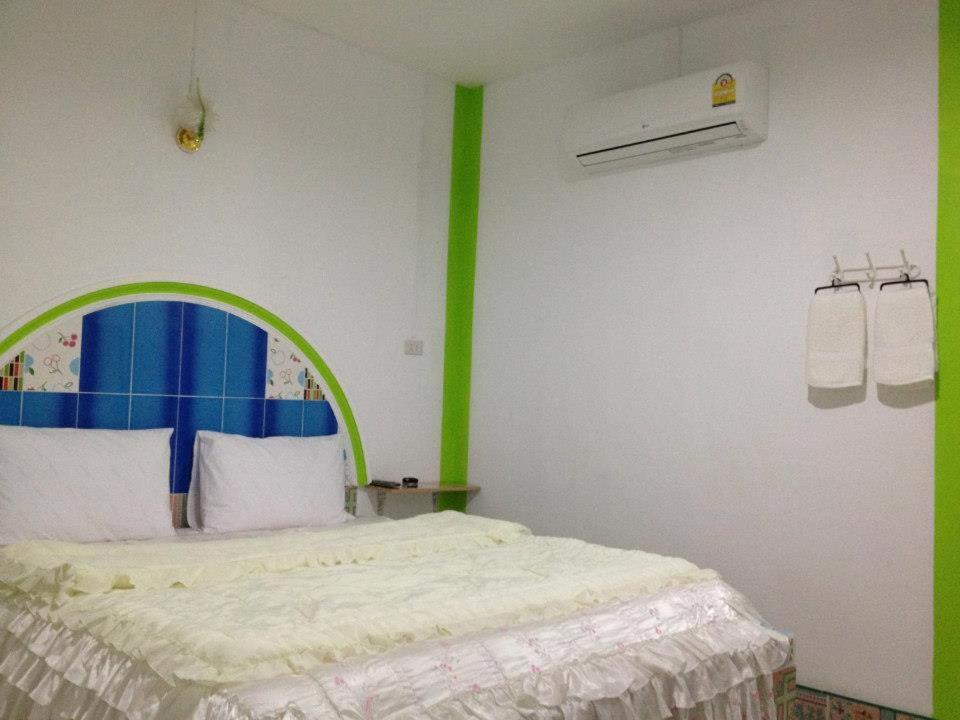 a bedroom with a bed with a green trim at Jidapha Rooms in Khlong Thom