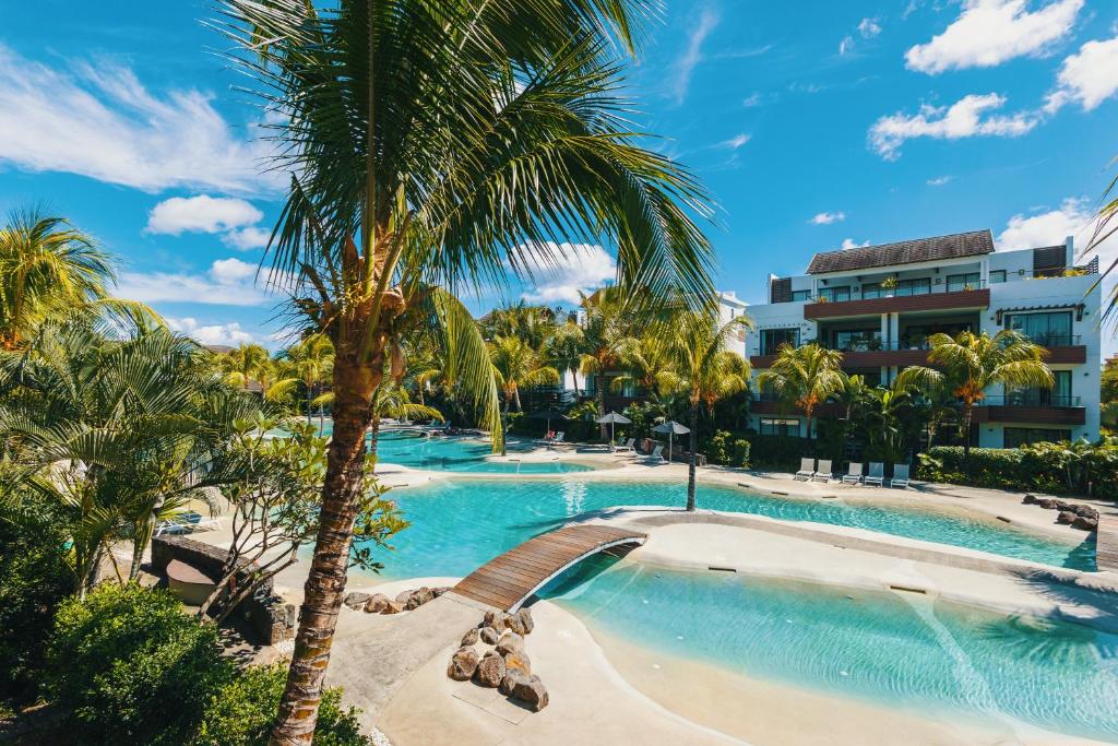 モン・ショワジーにあるLuxury Apt - Stunning Pool View - Beaches 2 minのヤシの木と建物のあるスイミングプール