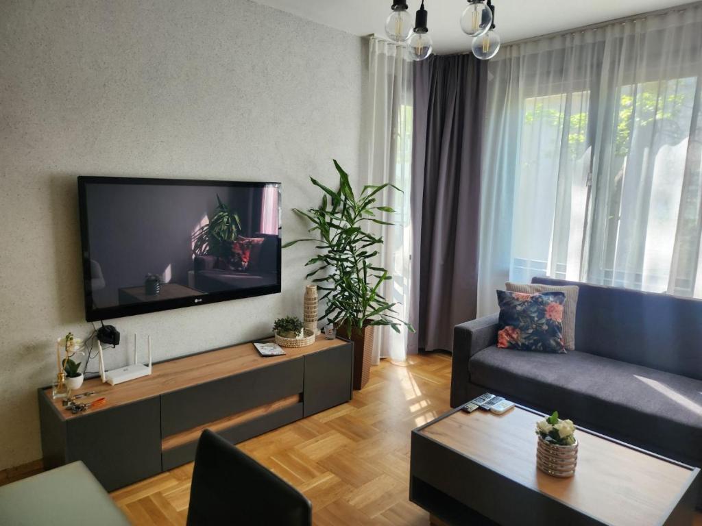 a living room with a couch and a flat screen tv at Апартамент 8 in Varna City