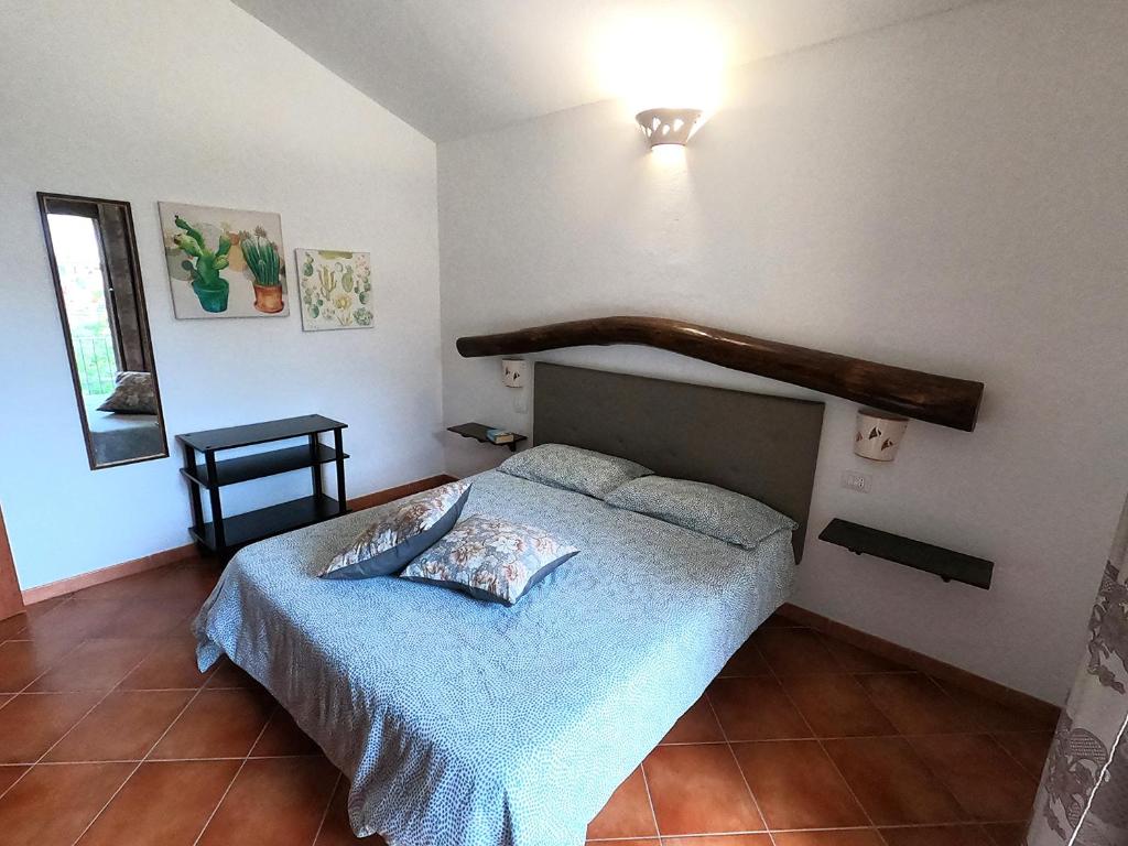 a bedroom with a bed with a wooden headboard at Yellon House in Santa Maria Navarrese
