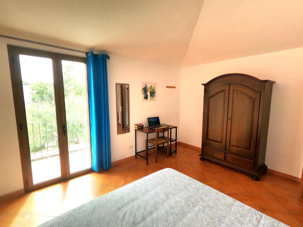 a bedroom with a bed and a table with a laptop at Yellon House in Santa Maria Navarrese