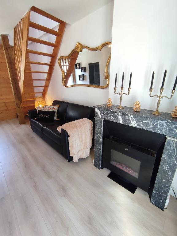 un salon avec une cheminée et un miroir dans l'établissement Le refuge chic, à Luchon