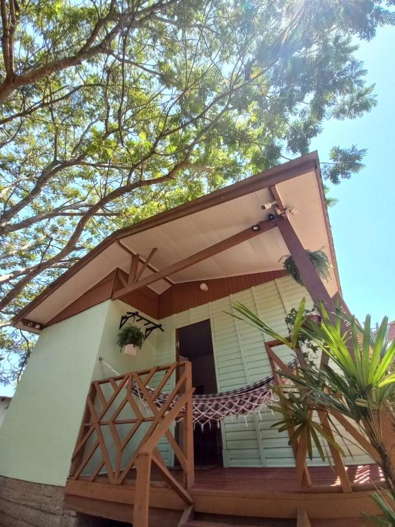 a small house with a porch and a balcony at Cabana Caminho de Pedras in Montenegro