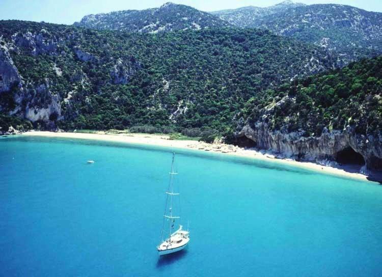 a sailboat in the water next to a beach at Yellon House in Santa Maria Navarrese