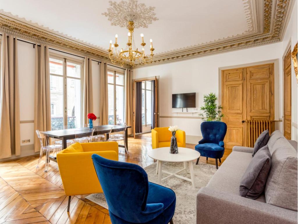 un salon avec un canapé, des chaises et une table dans l'établissement Merveil - Family Suite - Opera - Castellane, à Paris