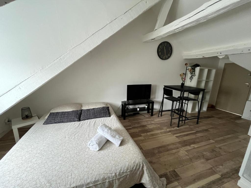 una camera da letto con un letto bianco e una scrivania di Studio cosy tout confort proche Cathédrale dans rue calme a Orléans
