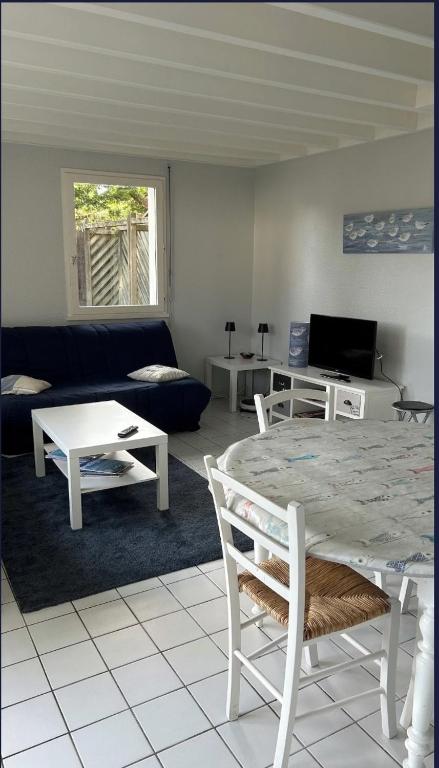 un salon avec une table et un canapé dans l'établissement Maison en résidence avec piscine à 3m de la plage, à Carnac