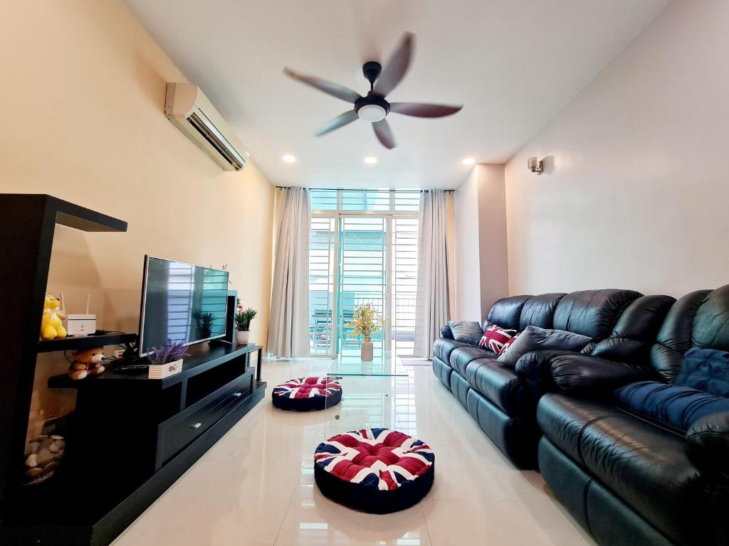 a living room with a black leather couch and a television at Subang SS16 Tiara Nu Empire SJMC Sunway Pyramid Lagoon Sunway Hospital INTI in Subang Jaya