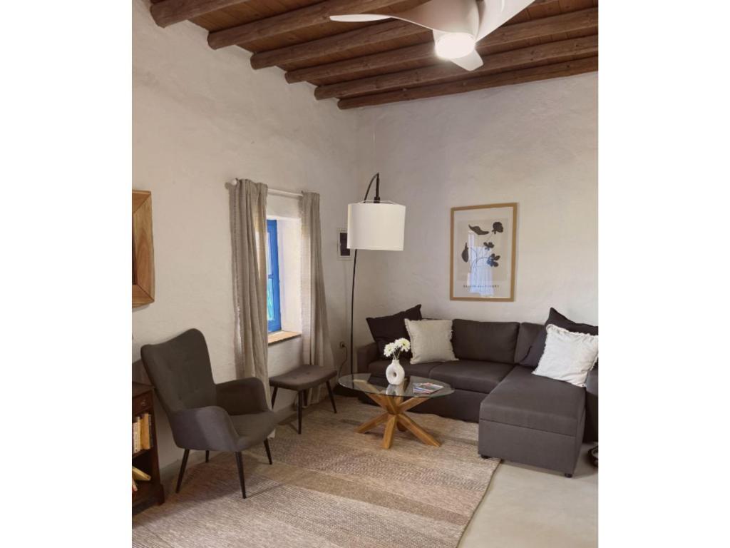 a living room with a couch and a table at Kotseli - Sea View, Pool, Sunsets in Andros