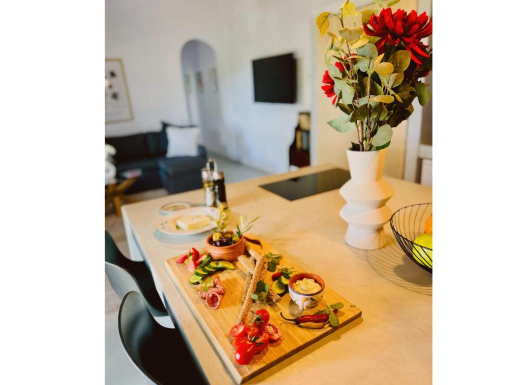 a plate of food on a table with flowers at Kotseli - Sea View, Pool, Sunsets in Andros