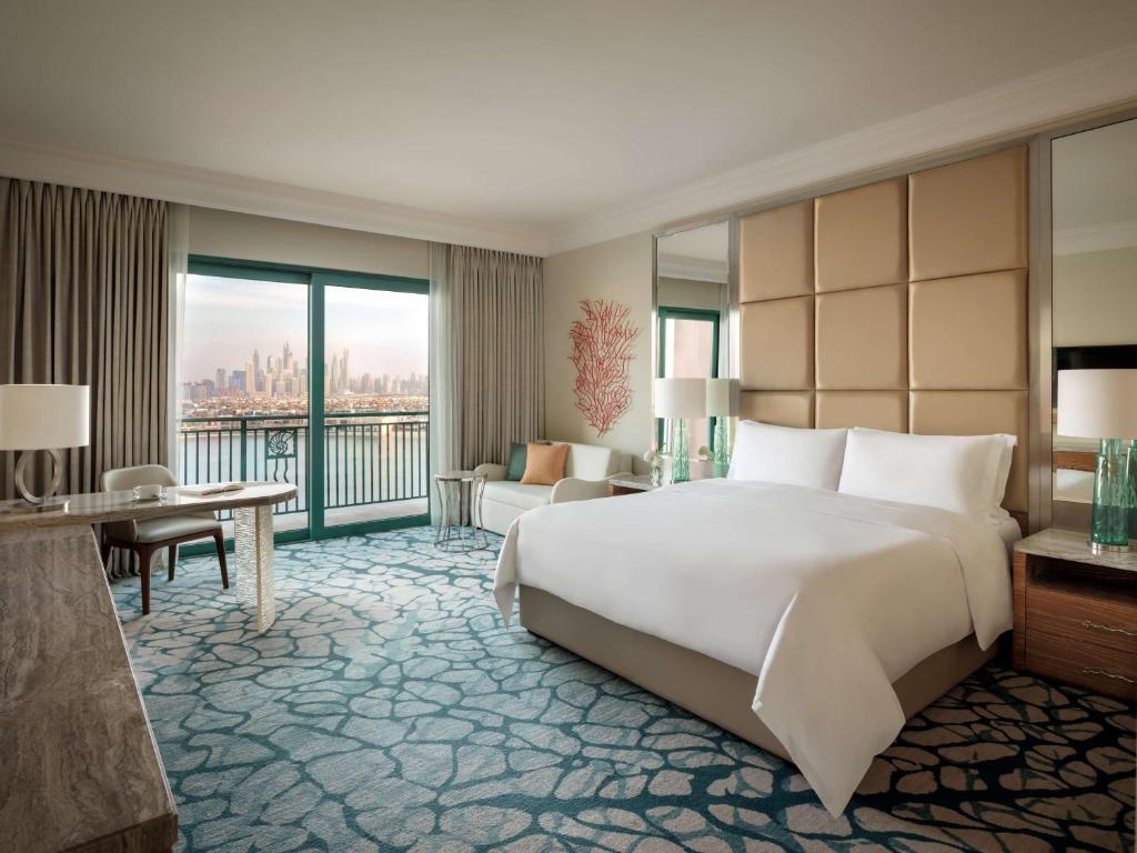 a hotel room with a large bed and a balcony at Atlantis, The Palm in Dubai