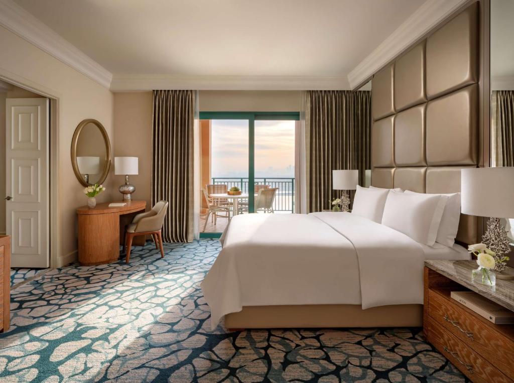 a hotel room with a large bed and a large window at Atlantis, The Palm in Dubai
