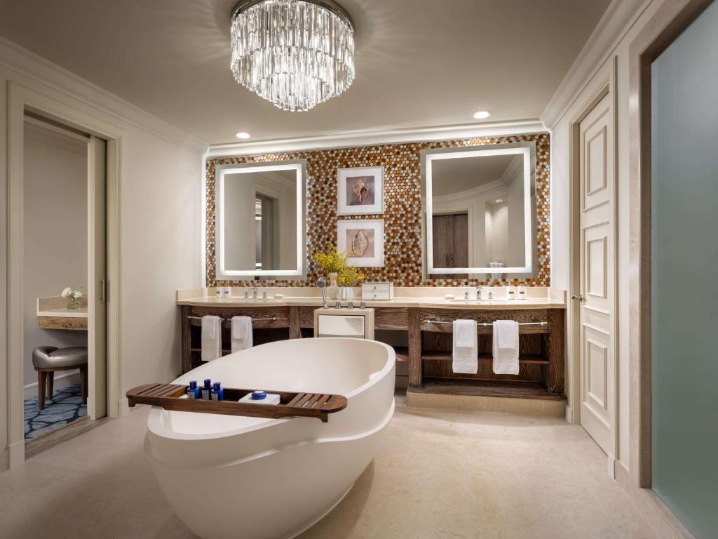 a bathroom with a tub and a sink and mirrors at Atlantis, The Palm in Dubai