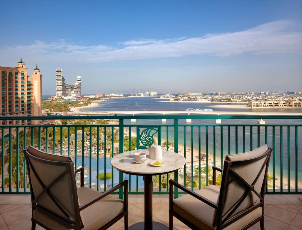 a table and chairs on a balcony with a view of the water at Atlantis, The Palm in Dubai