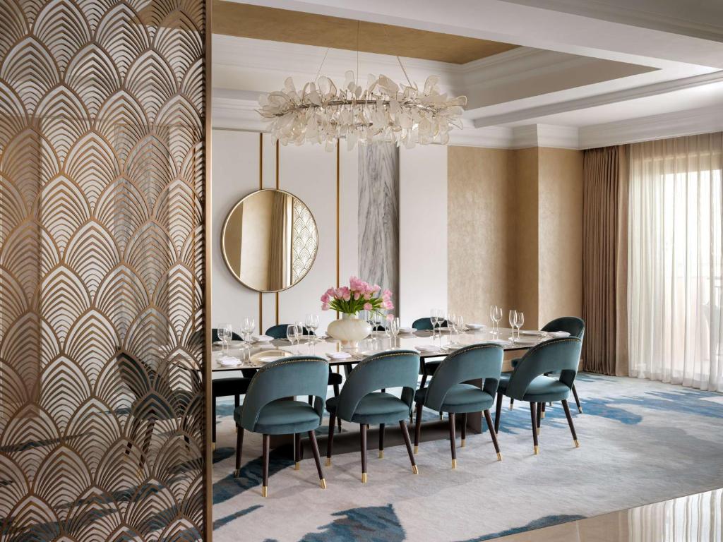 a dining room with a table and chairs and a chandelier at Atlantis, The Palm in Dubai