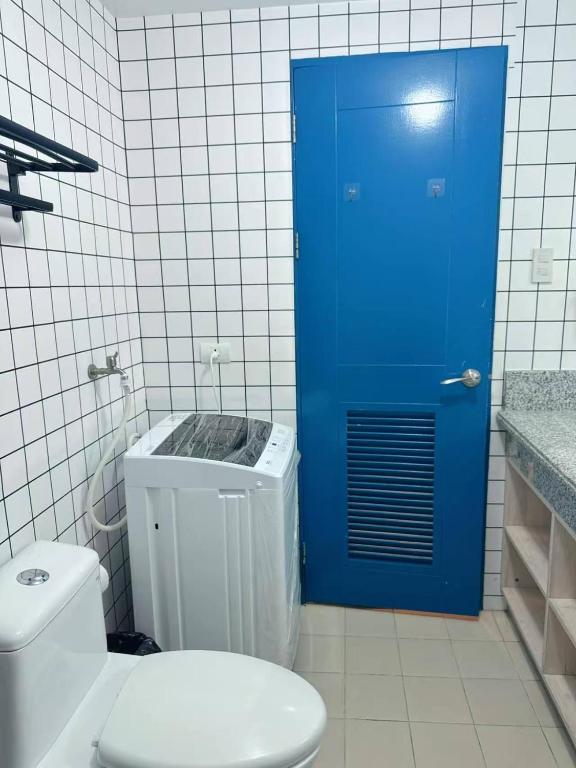 a blue door in a bathroom with a toilet at Torre De Manila in Manila