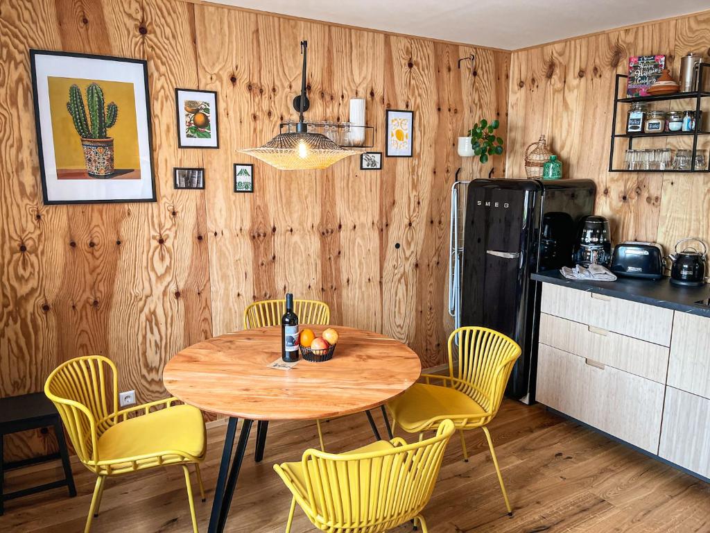 una cucina con tavolo con sedie e frigorifero di Hacienda Flats - Wunderschöne Ferienwohnungen am Seewald a Friedrichshafen