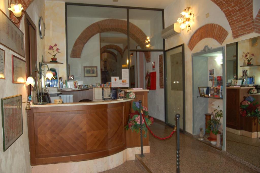 a restaurant with a counter and a bar in a room at Hotel Leonardo in Pisa