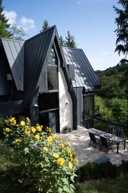 a black and white house with a table and flowers at Spa Villa Smetovi with Jacuzzi & Sauna in Zenica