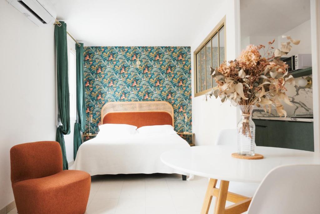 a bedroom with a bed and a table and a chair at Hôtel & Résidence San Roccu in Saint-Florent