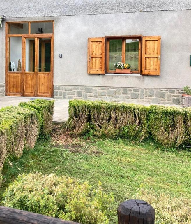 a house with wooden doors and a window at Lodge Pizzo Alpestre in Abetone