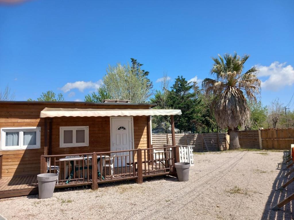 une petite maison avec une terrasse couverte et une clôture dans l'établissement Terrain avec Mazet climatisé proche des plages - V0847, à Vias