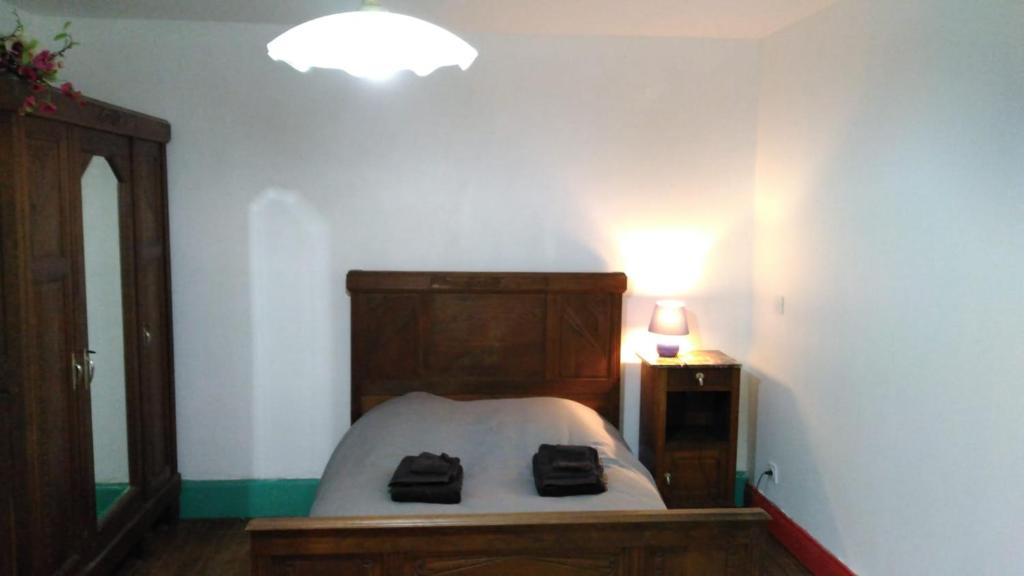 a bedroom with a bed with two black bags on it at Chez Alain in Fontenoy-le-Château
