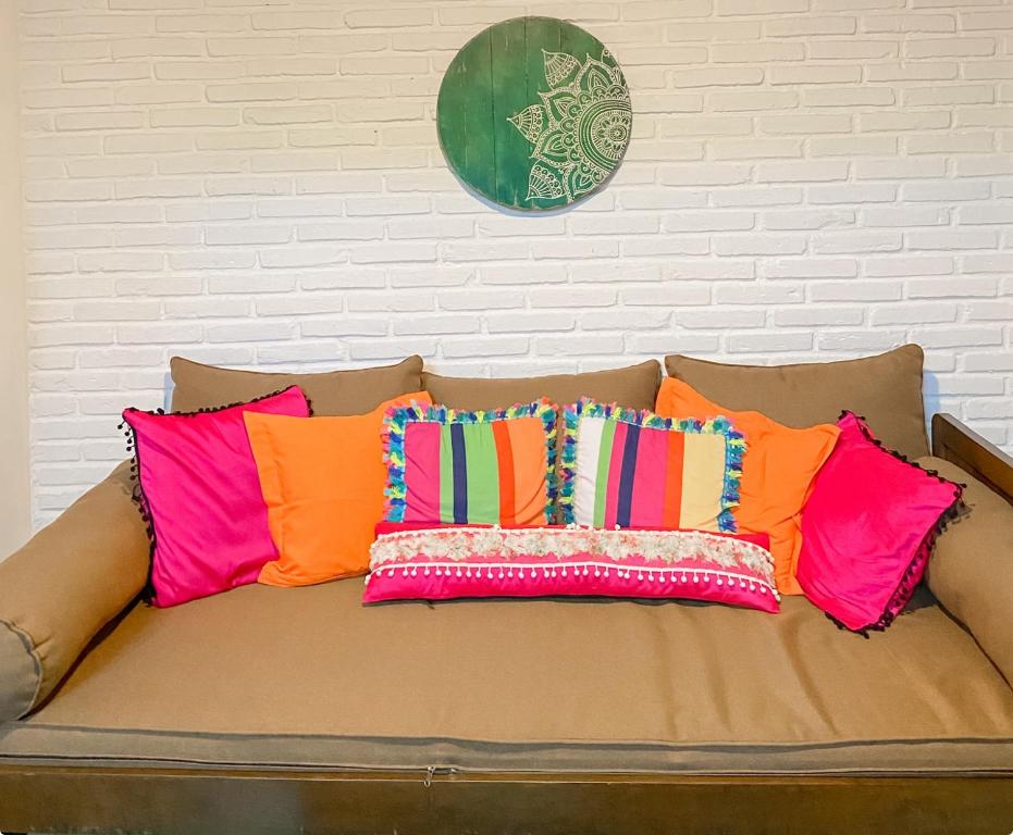 kanapę z 4 kolorowymi poduszkami w obiekcie Rumah Kayu Yogyakarta By Hamsa Putih w mieście Yogyakarta