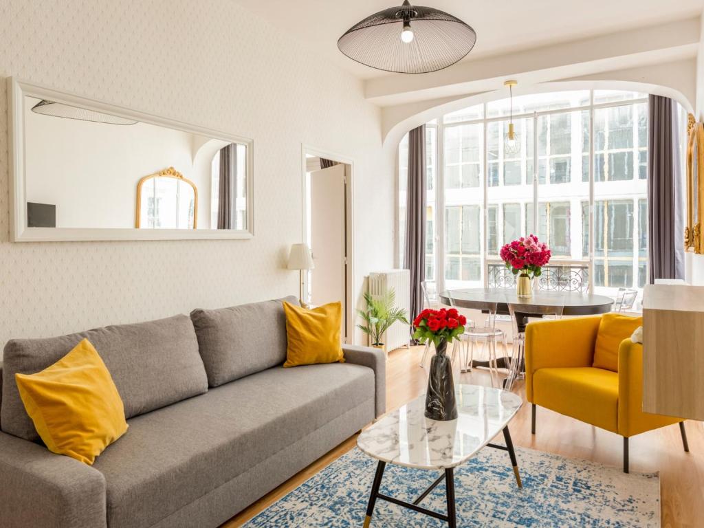 un salon avec un canapé et une table dans l'établissement Merveil - Family Suite - Louvre - Sentier II, à Paris