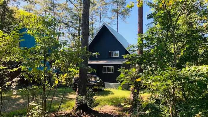 a black house with a car parked in front of it at Hakuba Cottage ICHIZAEMON by Jade Group in Hakuba