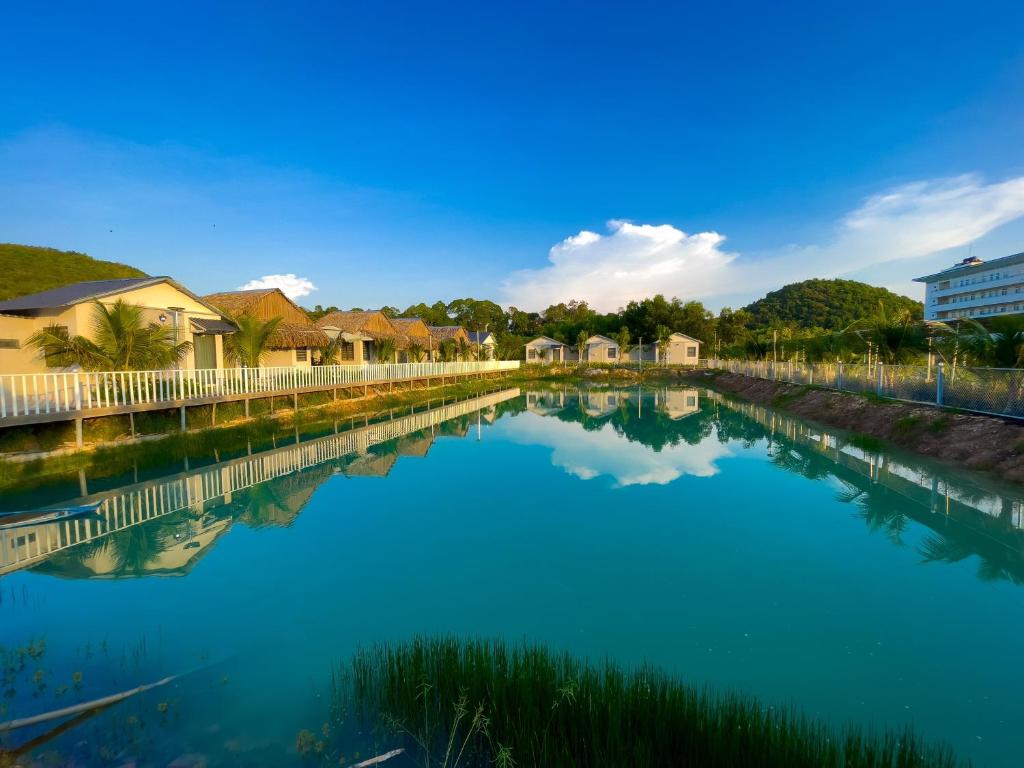 une grande masse d'eau avec des maisons et des bâtiments dans l'établissement Sai Gon Ha Tien Resort, à Hà Tiên