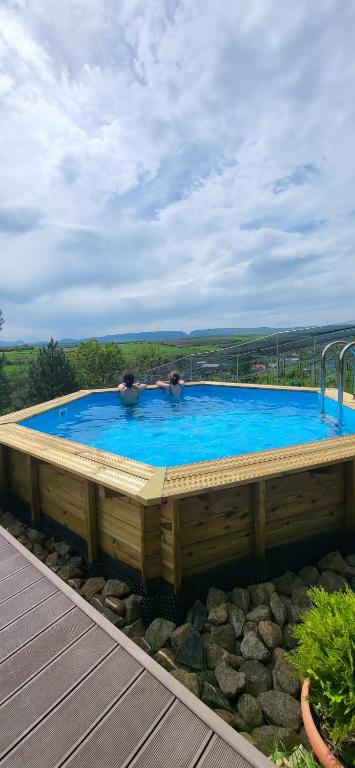 a large swimming pool with two people in it at Mobile Home CARMINO in Turda