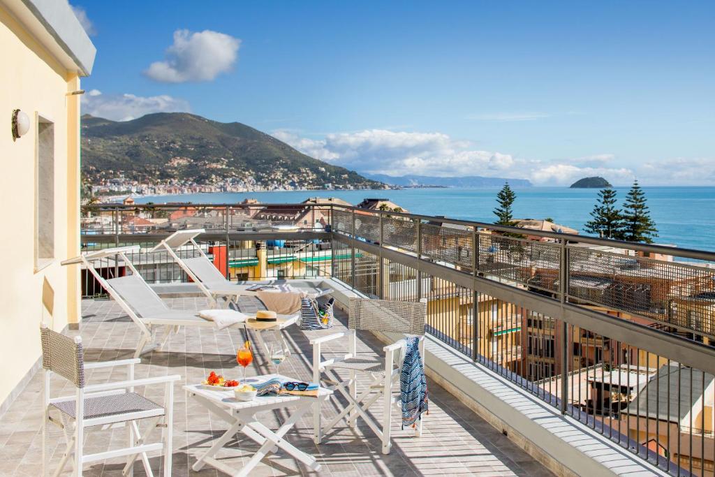 莱圭利亚Hotel Tritone的带椅子的阳台，可欣赏海景
