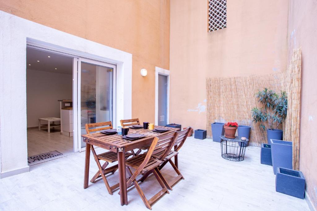 une table et des chaises en bois sur une terrasse dans l'établissement Iero - Avec Jacuzzi à 4min de la Plage, à Bormes-les-Mimosas