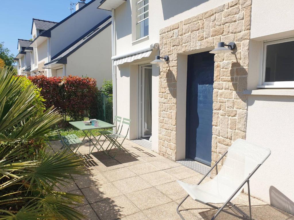 un patio avec deux chaises et une table à côté d'un bâtiment dans l'établissement RIVAGE 2 - Maison en bord de mer Carnac-Plage - C33, à Carnac