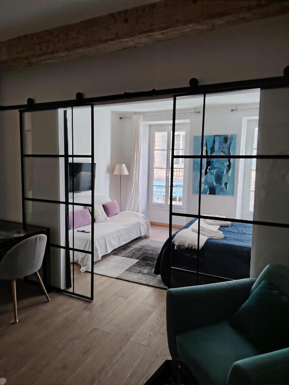une chambre avec deux lits et un grand miroir dans l'établissement Movida, à Nice
