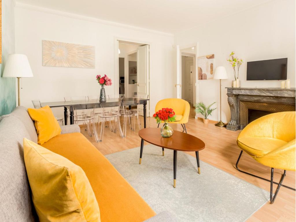 un salon avec un canapé et une table dans l'établissement Merveil - Family Suite - Champs Elysees - Mollien, à Paris